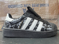 Adidas Concha negro blanco periódico