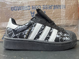 Adidas Concha negro blanco periódico